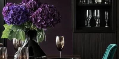 Elegant table setting with purple hydrangeas, black dinnerware, and teal velvet chairs
