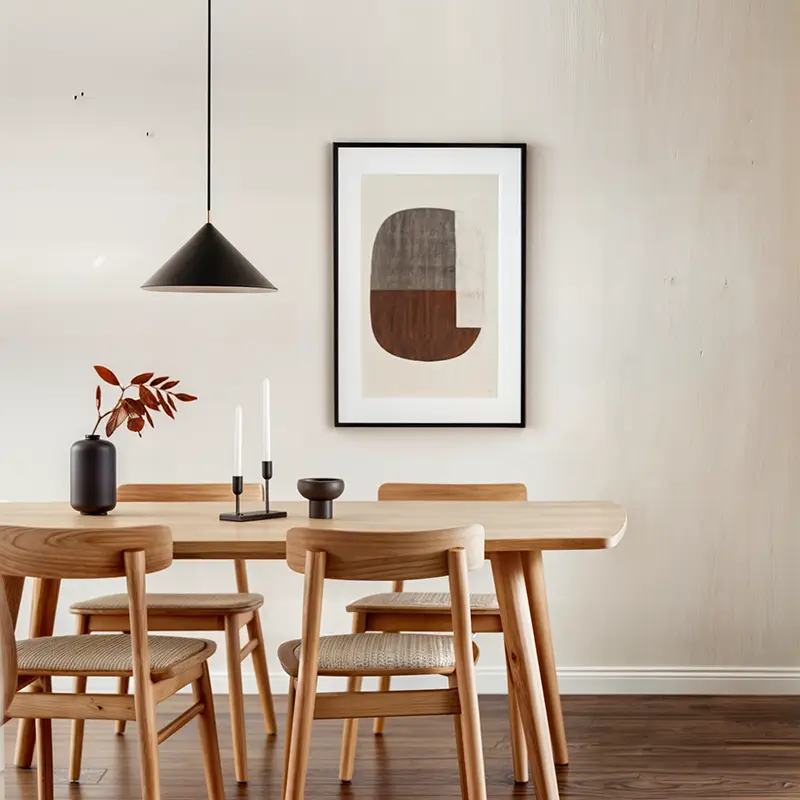 Warm minimalist dining room with light wood table, black pendant light, abstract artwork and terracotta accents demonstrating the 60-30-10 color rule
